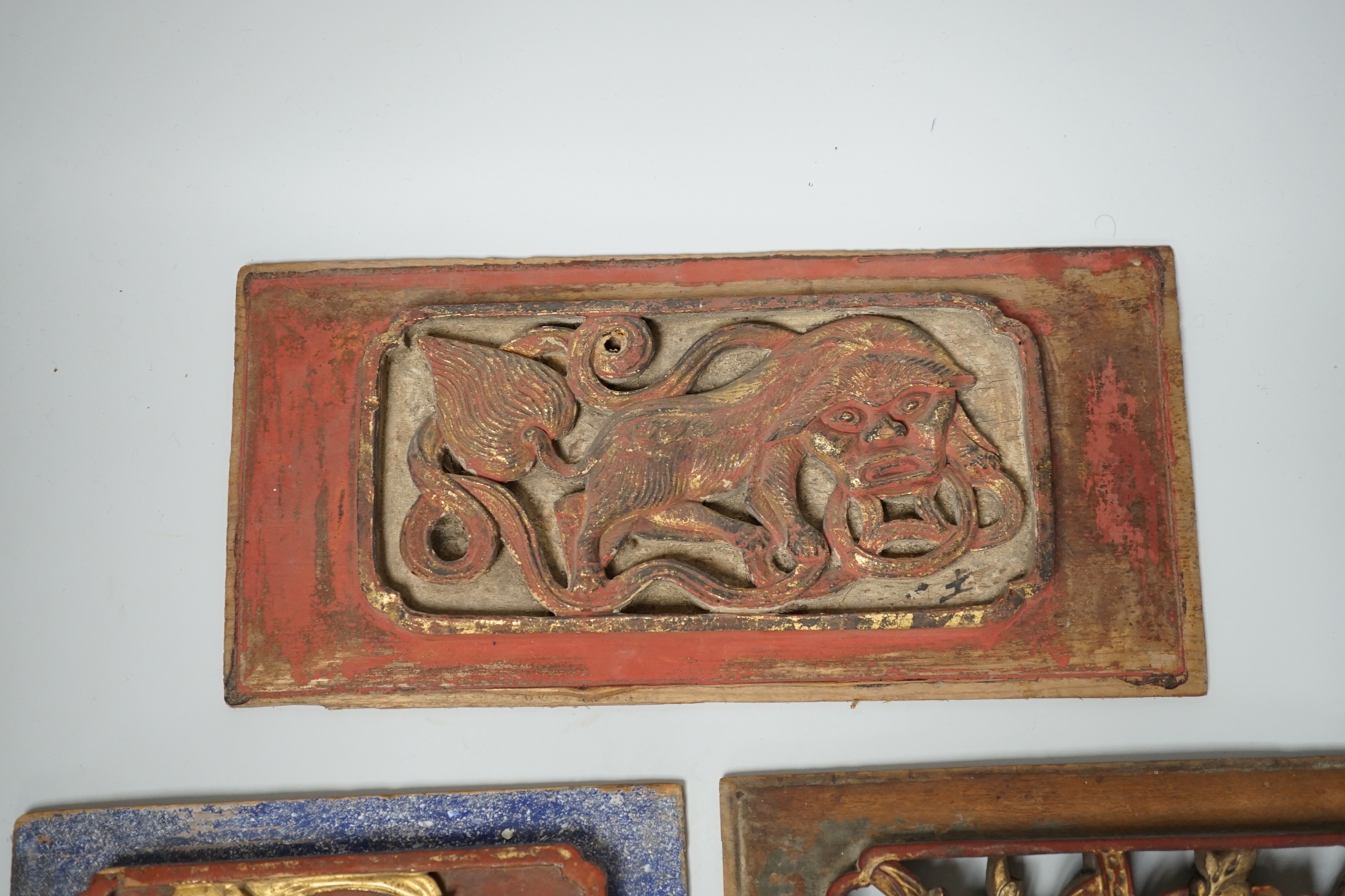 Three Chinese gilded and lacquered wood panels, early 20th century, longest 31cm